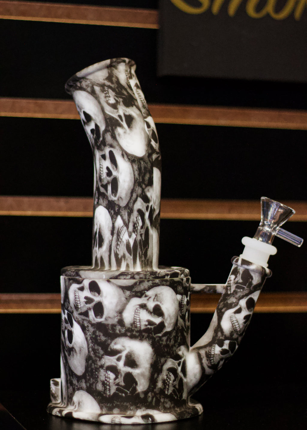 Glass smoking device with skull pattern on a black background